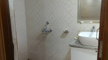 A bathroom with a shower, a sink, and a mirror.