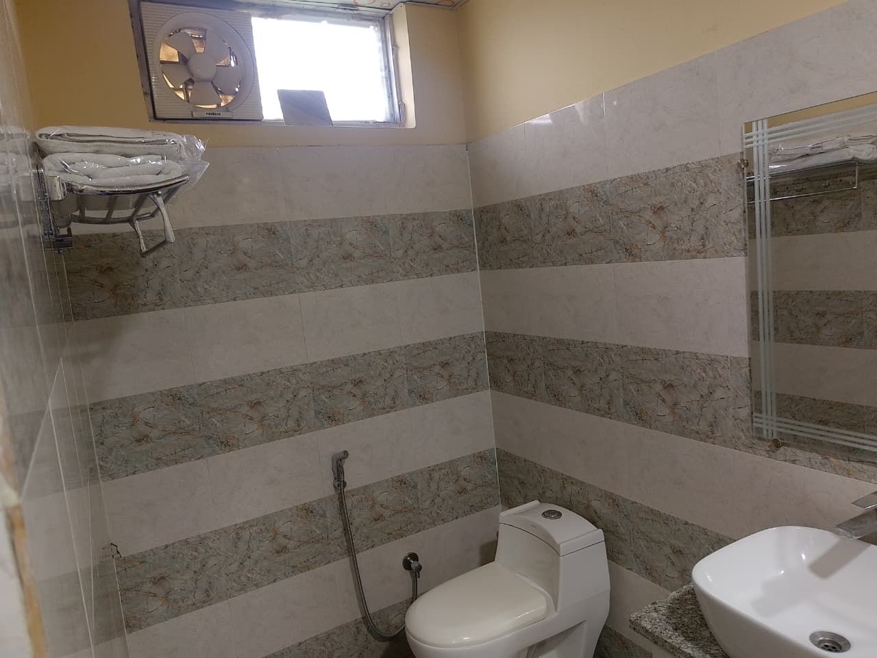 A bathroom with a toilet, a sink, and a shower.