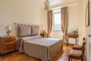 Ein Schlafzimmer mit einem Bett, Nachttischen, einem Schreibtisch und einem Sessel.