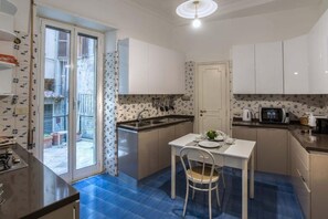 Cozinha compacta com área de refeições, forno embutido e micro-ondas.