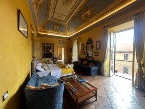 A hotel room with a bed, a sofa, a coffee table, and a balcony with a view. - antico suites roma (Roma)
