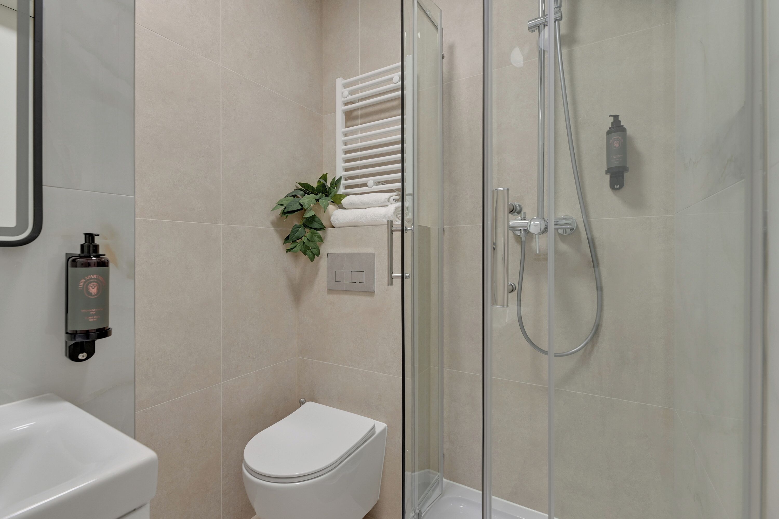 A bathroom with a toilet, a shower, and a sink.