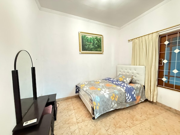 A bedroom with a bed, a dresser, a mirror, a window with curtains, and a framed picture on the wall. - Kuca Plava (Cimenyan)