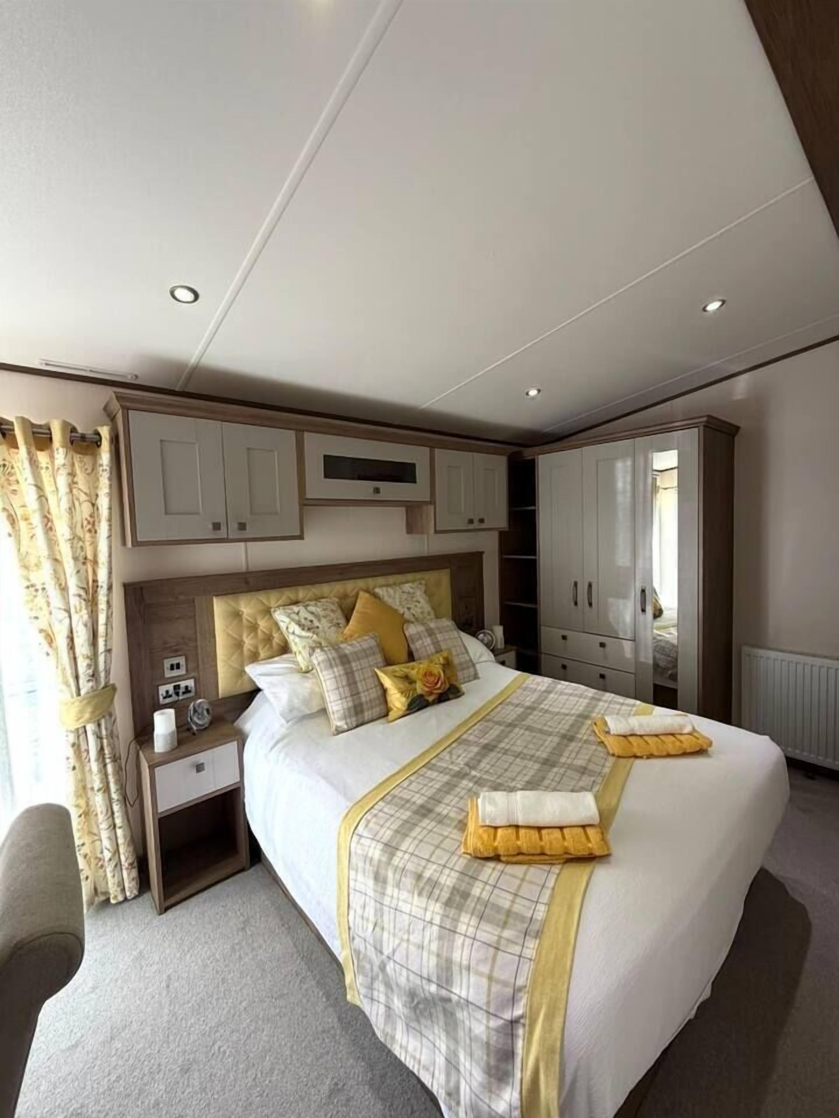 A hotel room with a large bed, bedside tables, a wardrobe, and a radiator.