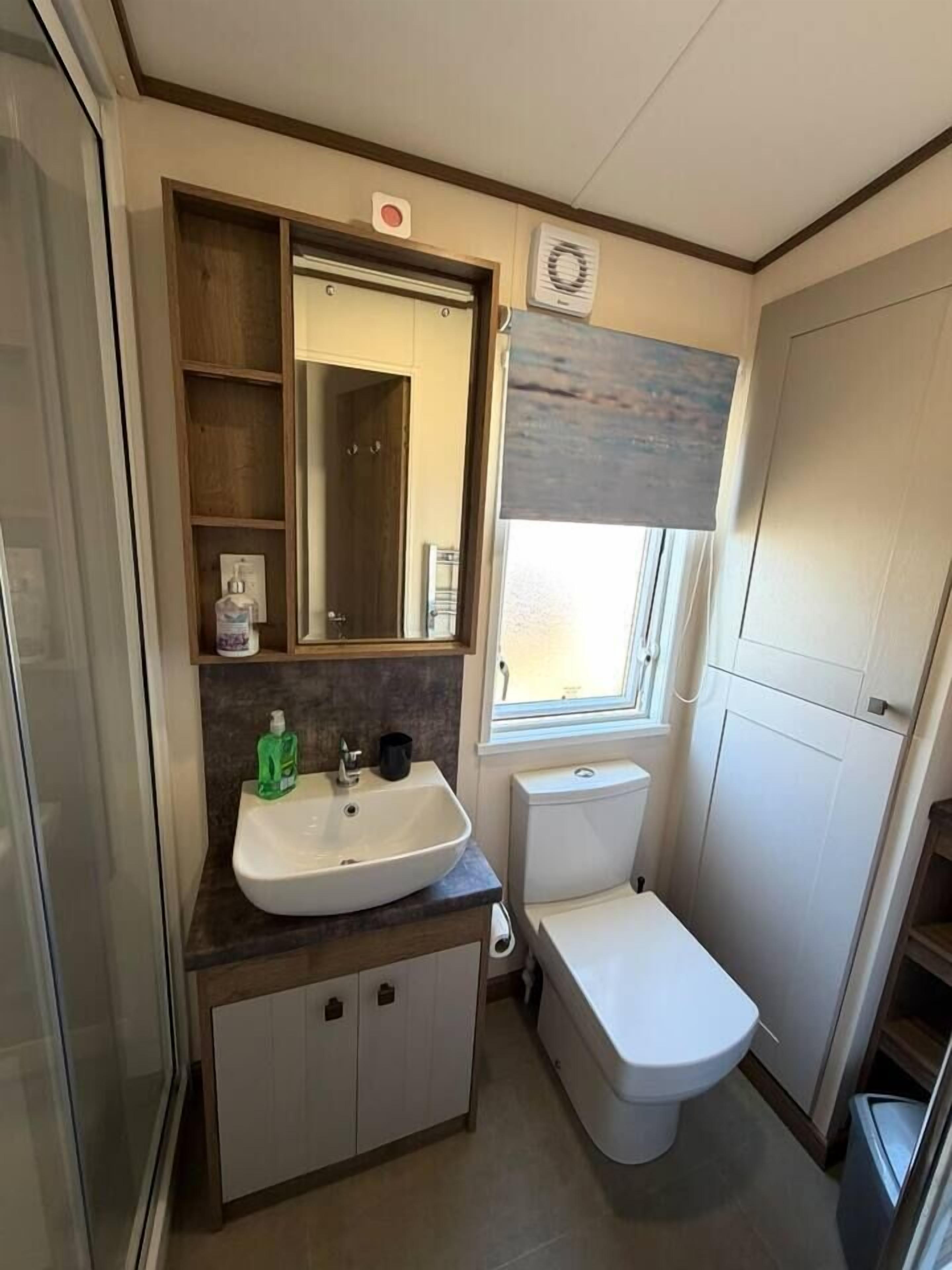 Een kleine badkamer met een wastafel, spiegel en toilet.