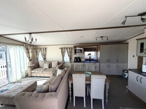 A compact living space with a sofa, dining table, and kitchenette.