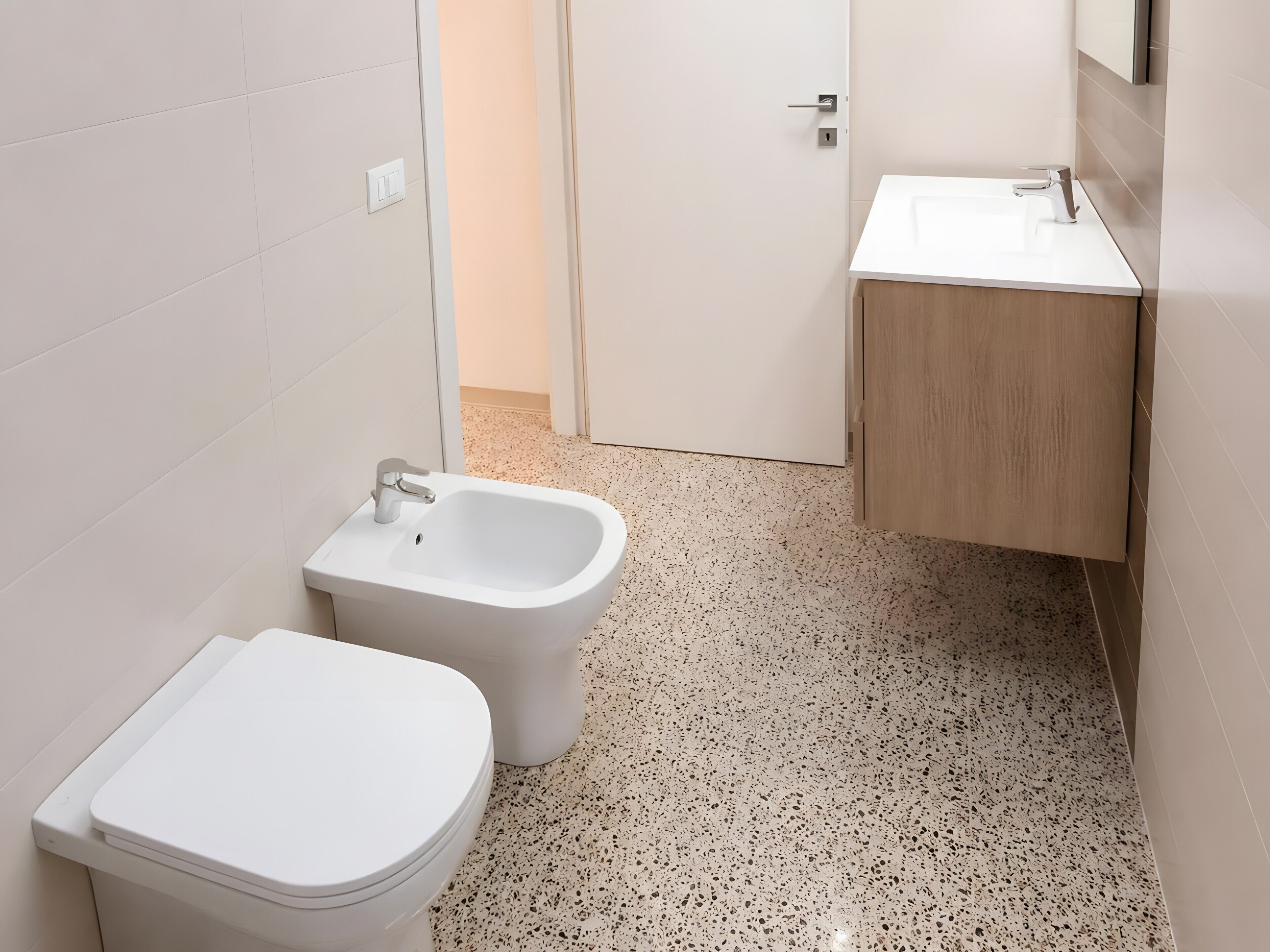 Un bagno con un WC, un bidet e un lavandino.
