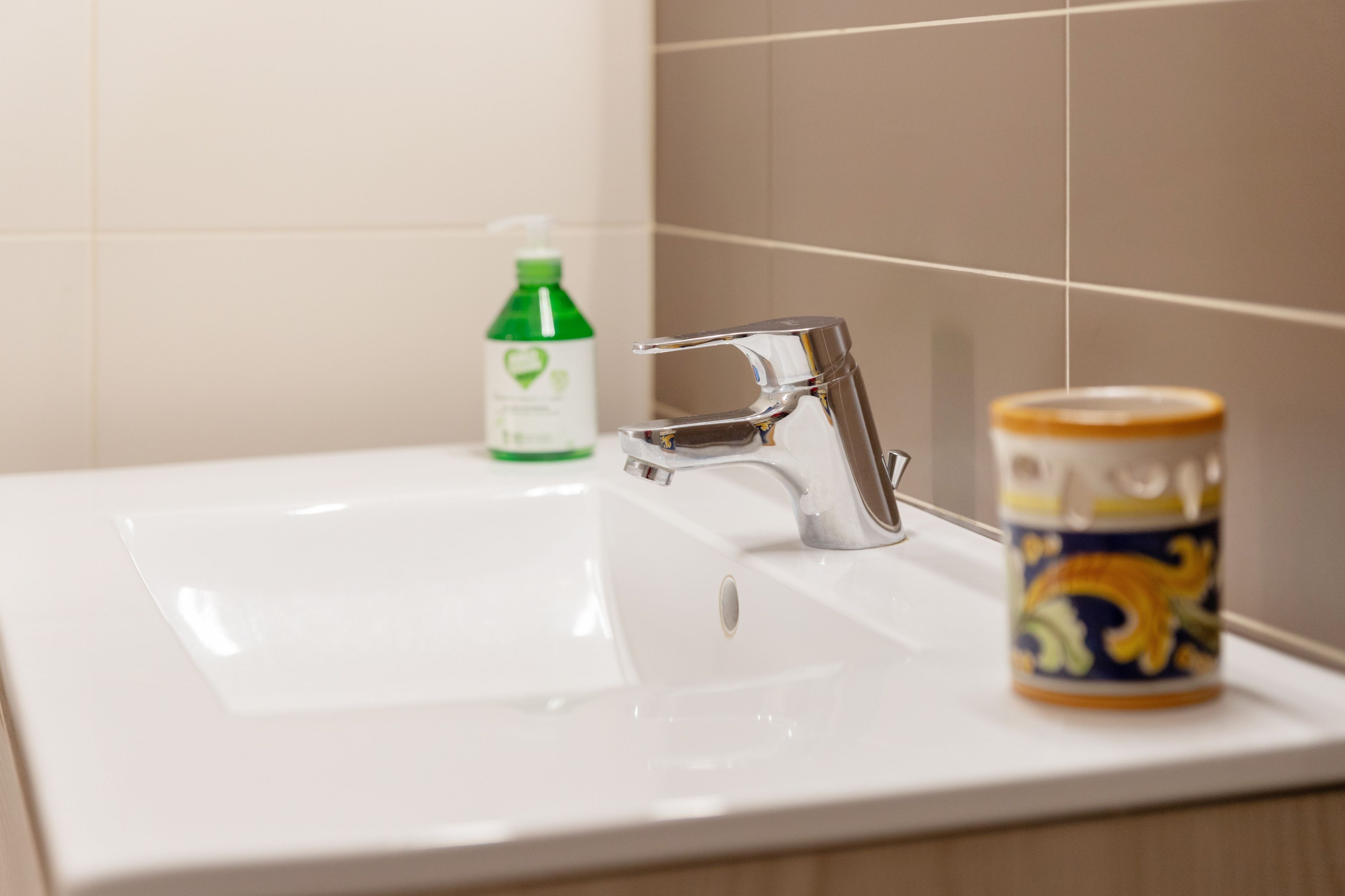 A bathroom sink with a faucet and a bottle of mouthwash.