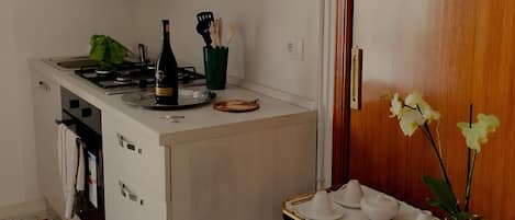 Cafetera o tetera, frigorífico, horno y placa de cocina