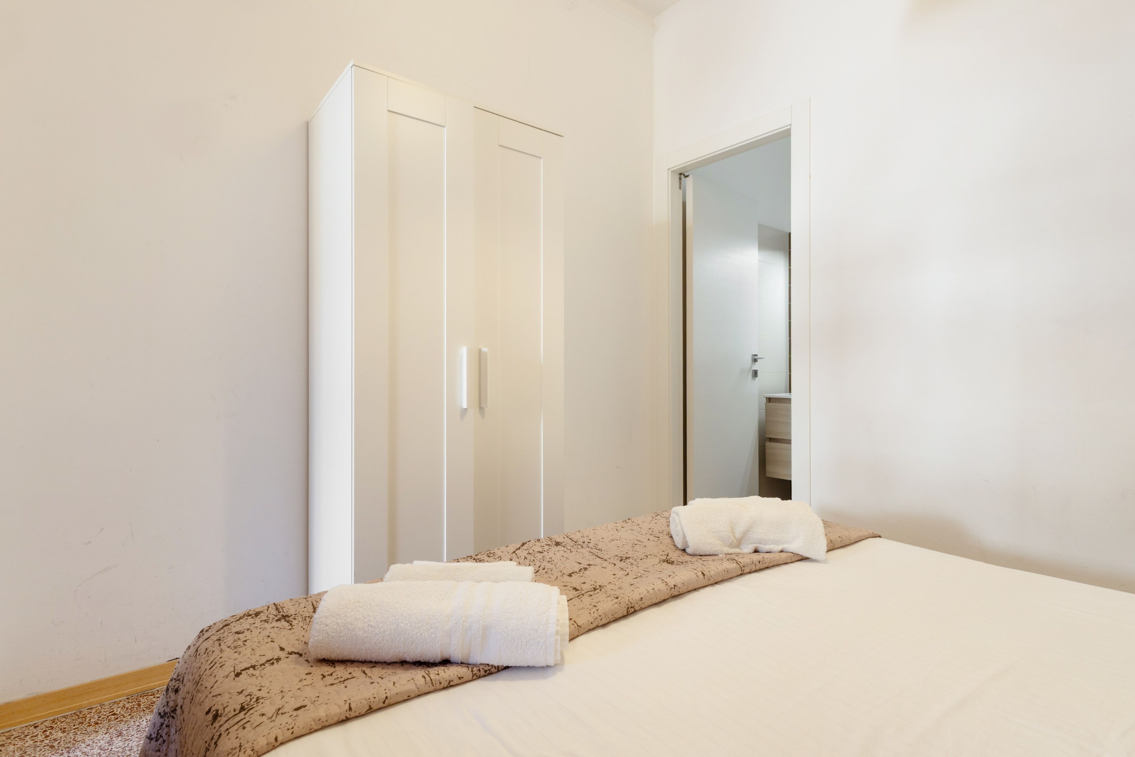 Une chambre d’hôtel avec un lit, une armoire et un miroir.