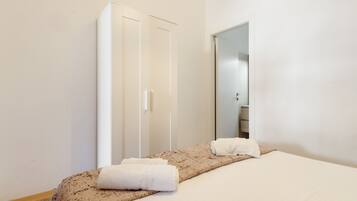 Une chambre d’hôtel avec un lit, une armoire et un miroir.
