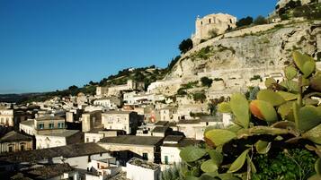 A coastal town with historic buildings, a prominent church, and a castle on a hill.