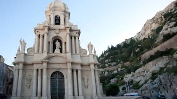 A historic church with a bell tower, arched entrance, and statues.