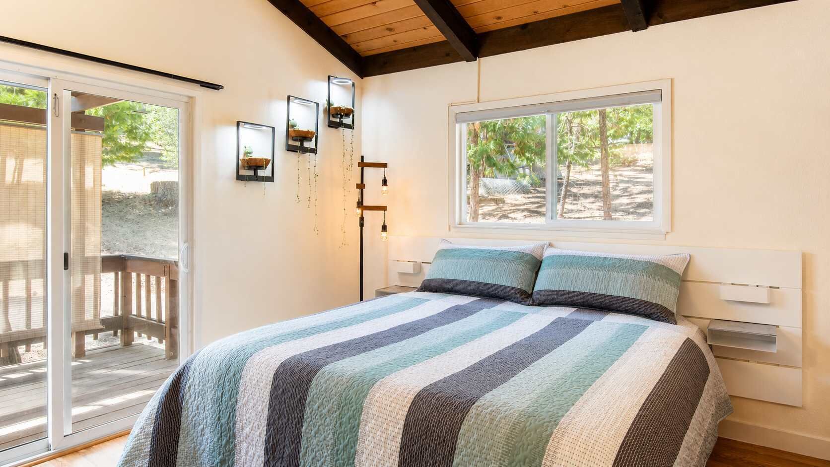 A bedroom with a large bed, a window, and a view of the outdoors.
