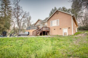A two-story house with a deck, a garage, and a grassy yard. - Oakhurst 3BR - Hot Tub, Games & Yosemite (Oakhurst)