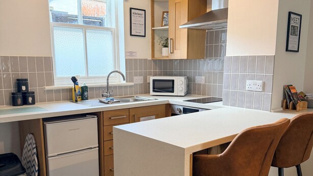 A compact kitchen with a central island, a microwave, and a sink.