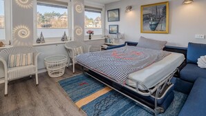Una camera da letto con un letto, due sedie, un tavolino e una finestra vista.