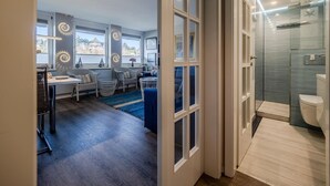 Un interno moderno con zona pranzo, cucina e bagno con doccia e servizi igienici.