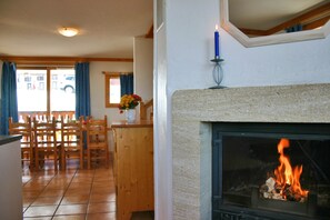 A cozy room with a fireplace, wooden furniture, and a view through a window. - Chalet Privé 10p, cheminée (Macot-la-Plagne)