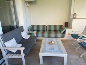 Un salon aménagé comprenant un canapé, deux fauteuils, une table basse et un petit objet décoratif.
