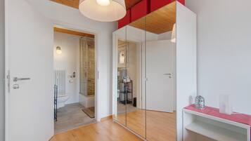 Ein modernes Badezimmer mit einer Duschkabine aus Glas, einer weißen Toilette und einem Spiegelschrank.