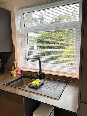 A kitchen with a window, sink, and countertop.
