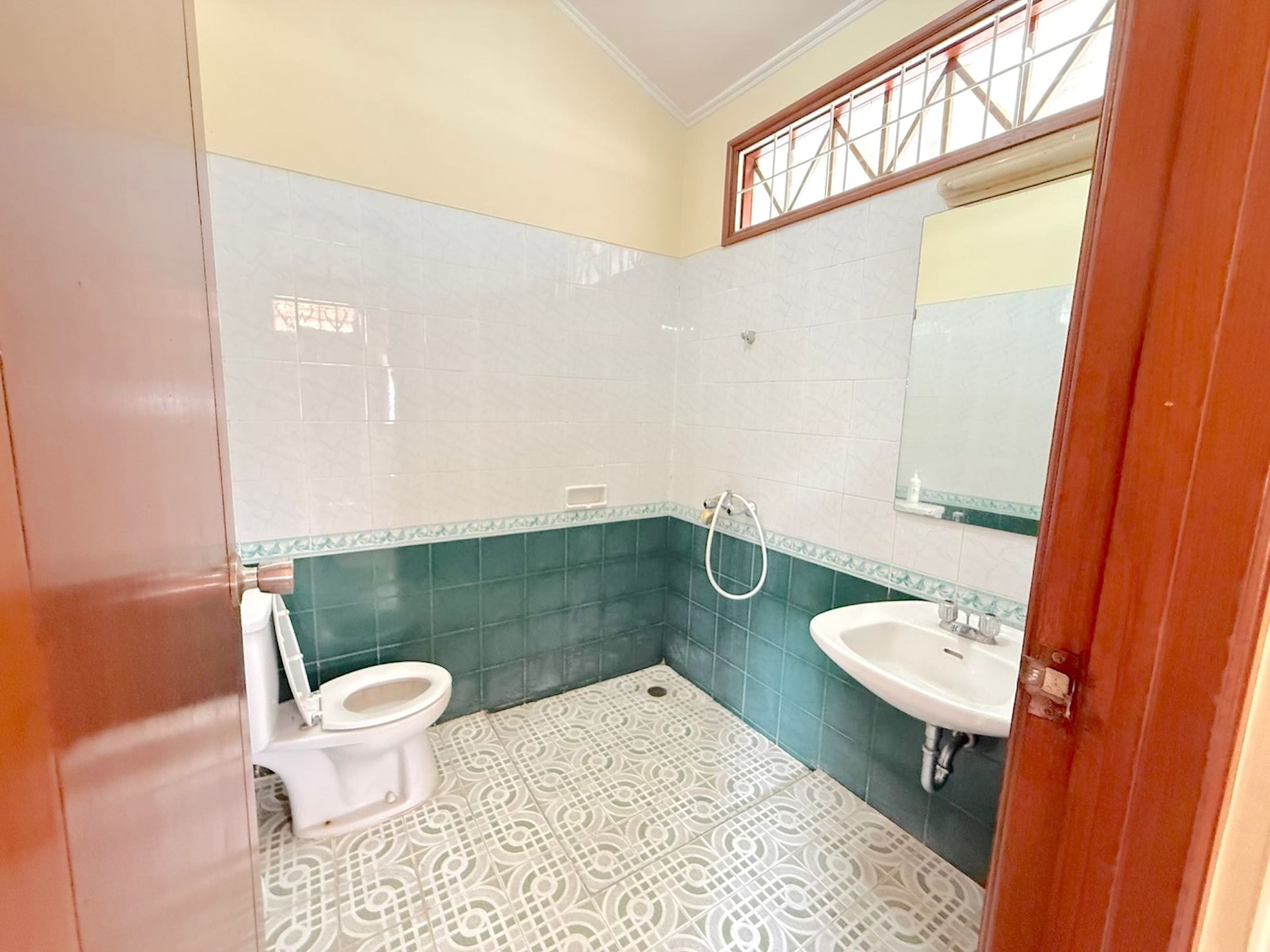 Une salle de bain avec des toilettes, un lavabo et une douche.