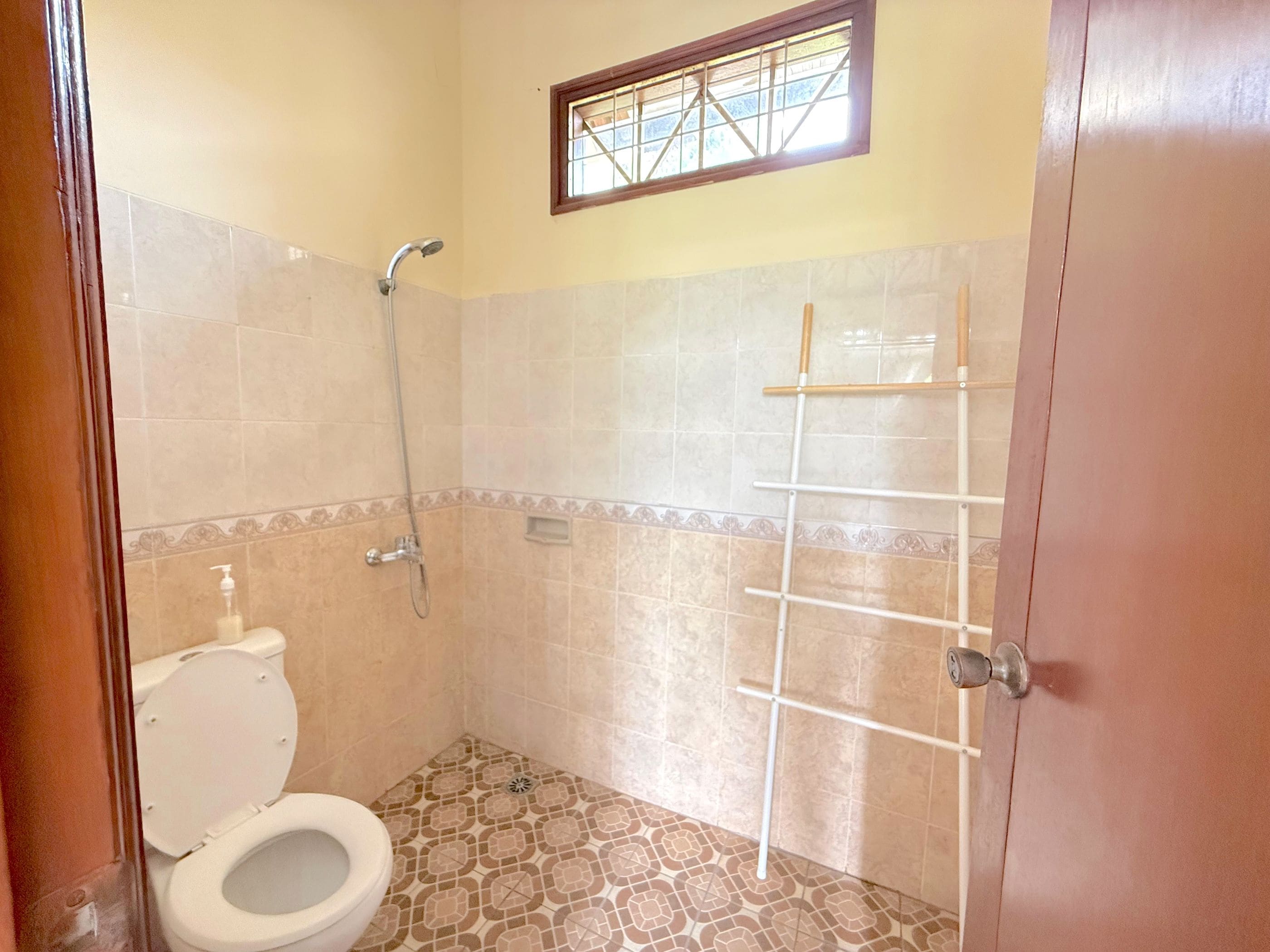 Ein Badezimmer mit Toilette, Dusche und einem Fenster.