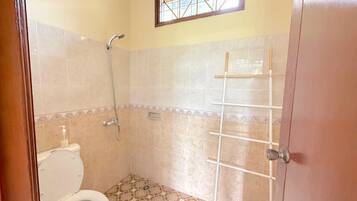Ein Badezimmer mit Toilette, Dusche und einem Fenster.
