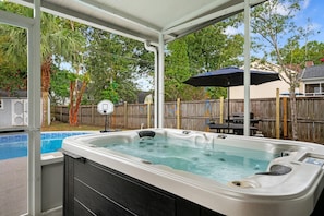 A hot tub with a view of a backyard, a basketball hoop, and a wooden fence. - The Chantrell Pool Hot Tub Pets (North Charleston)
