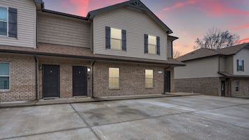 A two-story building with a brick facade and multiple doors.