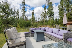 An outdoor seating area with a sofa, chairs, and a table.
