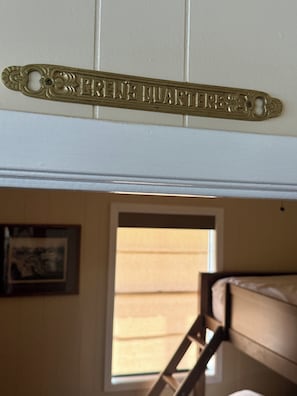 Una habitación con literas, una escalera, un cuadro en la pared y una ventana con vistas.