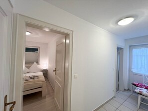 Ein Schlafzimmer mit Bett, Nachttisch und einem fenster mit Vorhängen.