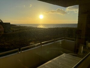 Ein Balkon mit Blick auf den Sonnenuntergang über dem Meer.