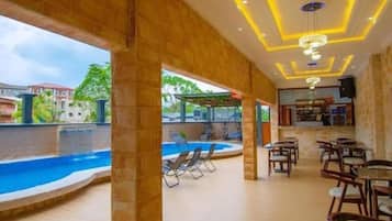 Un área de piscina interior con bar y asientos.