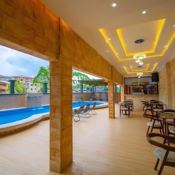 An indoor pool area with a bar and seating.