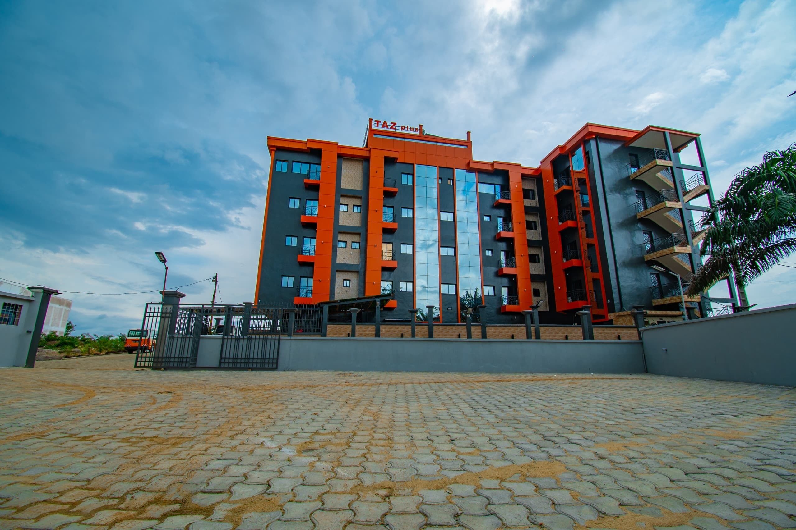 Un edificio a più piani dal design architettonico moderno, con una predominante combinazione di colori rosso e grigio.