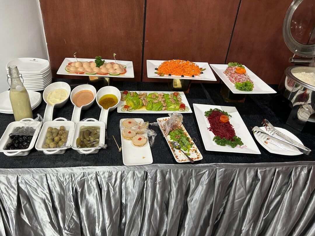 A buffet table with various food items and condiments.