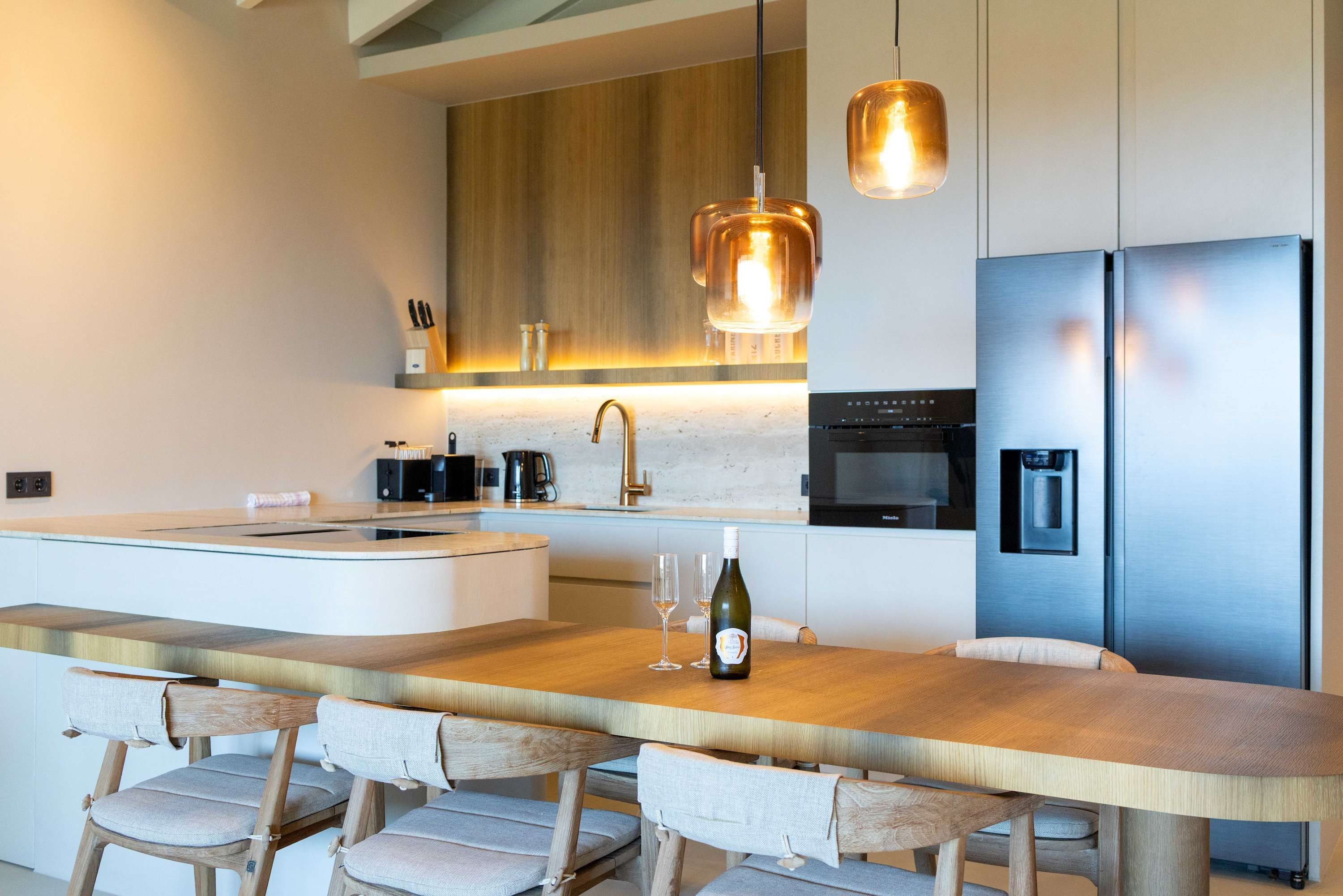 A modern kitchen with a central island, stainless steel appliances, and a pendant light.