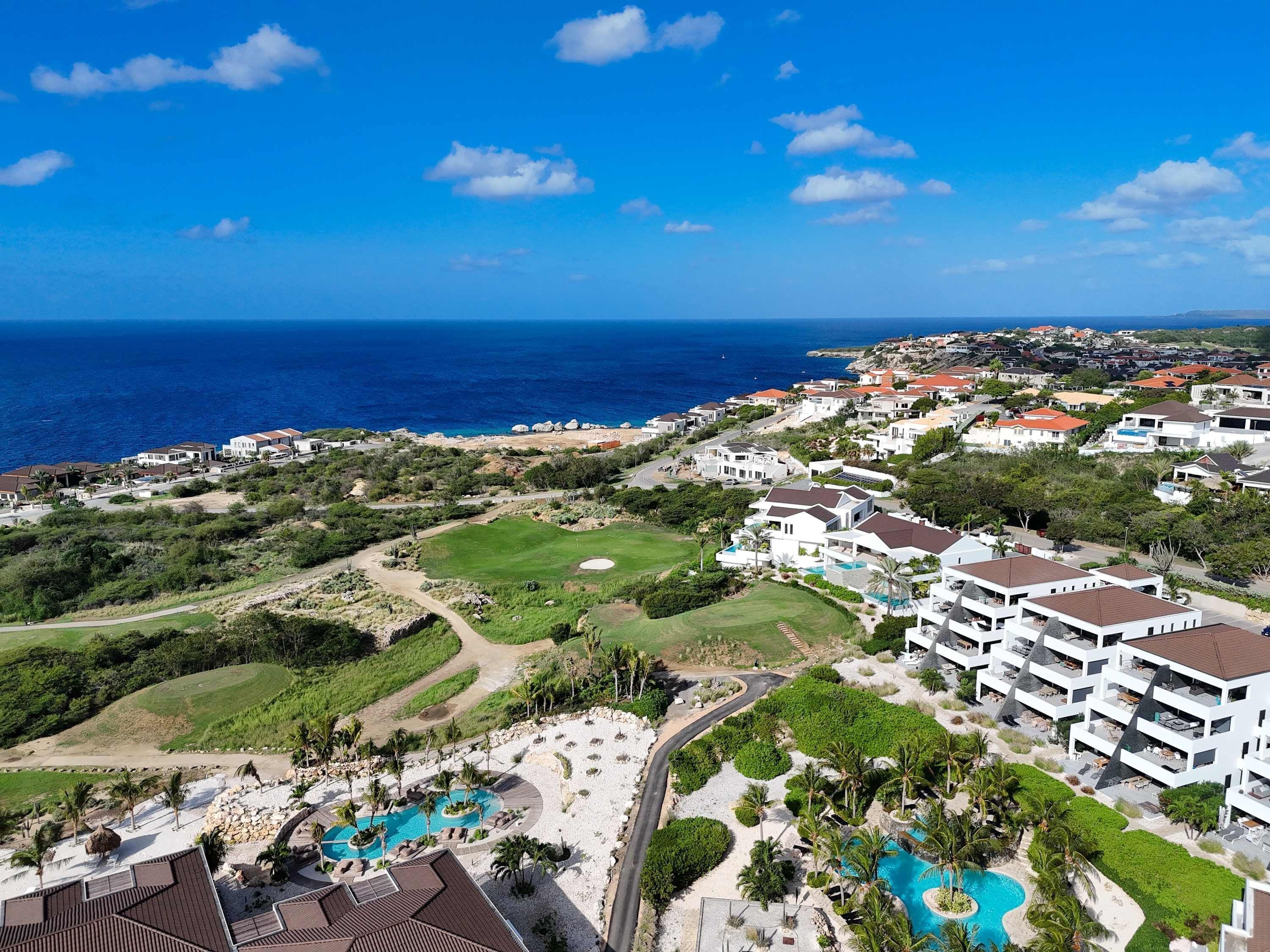 A resort with multiple swimming pools, a golf course, and ocean views.
