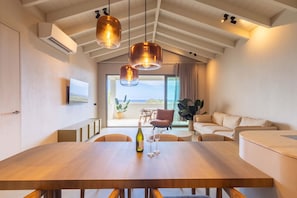 A dining area with a wooden table, chairs, and pendant lighting. - Sapphire at The Reef - Ocean View Penthouse (Sint Michiel)