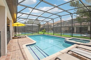 A pool area with a glass enclosure, lounge chairs, and a hot tub. - Upstay Family Home w Pool Cinema Championsgate (Davenport)