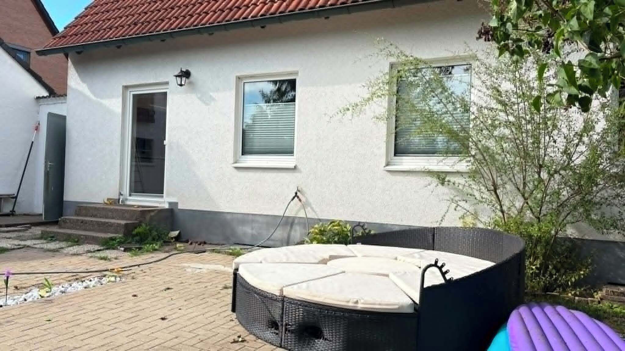 A house with a patio area featuring a round outdoor seating arrangement.
