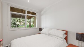 A bedroom with a bed, a window, and a nightstand. - Unit 1 PI Holiday Retreat (Cowes)