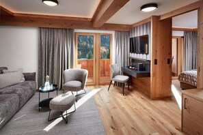 A modern living room with a sofa, two armchairs, a coffee table, and a TV. - Hotel Gletscherblick (Sankt Anton am Arlberg)