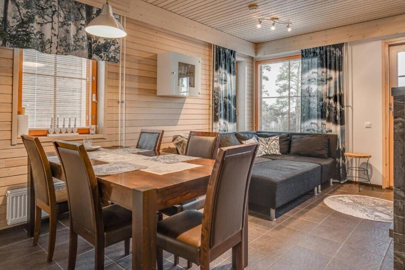 A cozy interior with a dining area, a sofa, and a fireplace.