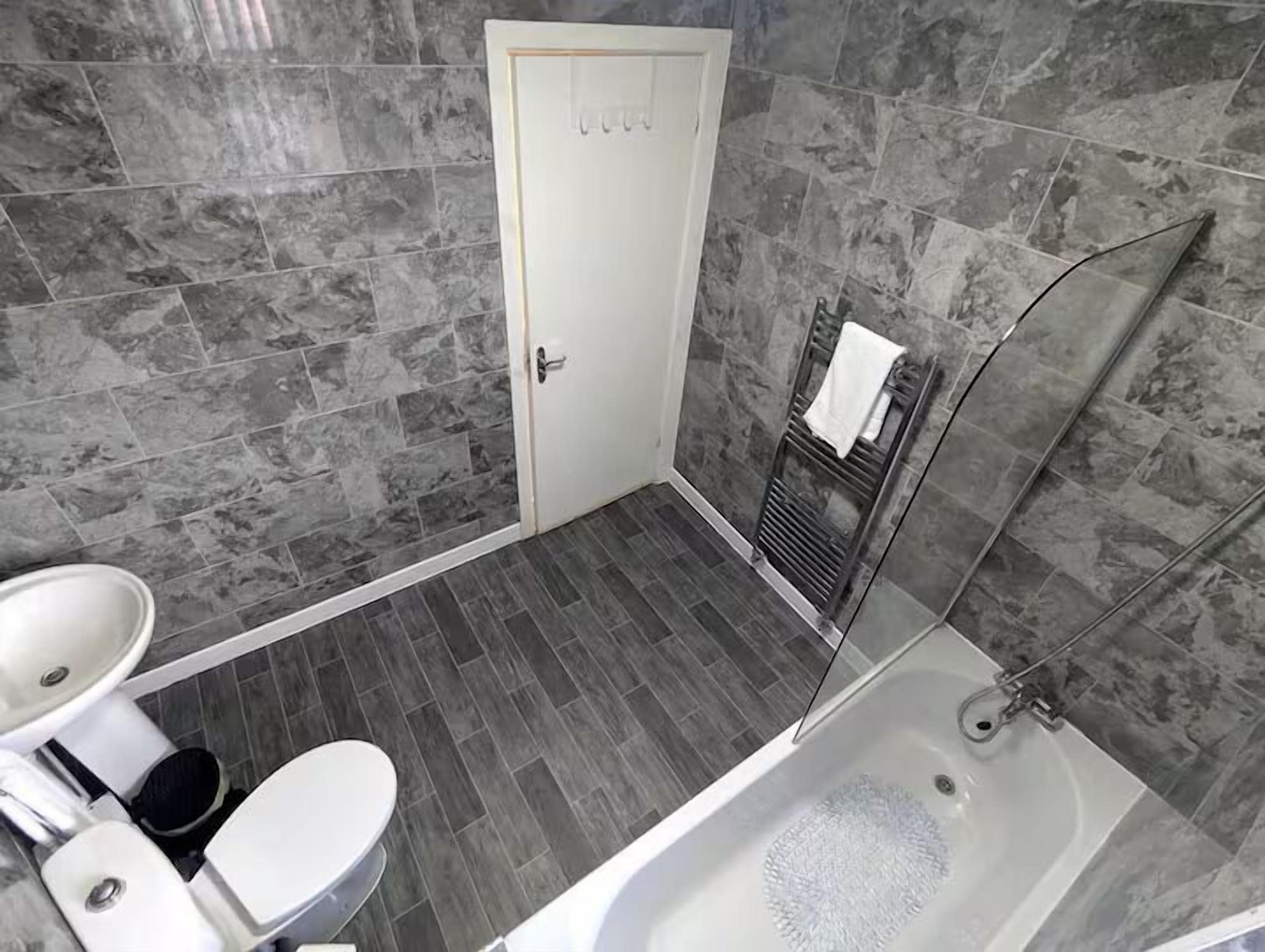 A bathroom with a bathtub, toilet, and sink.