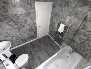 Un baño con bañera, inodoro y lavabo.