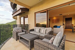 A balcony with wicker furniture, a sofa, and a coffee table. - Hermosa del Mar 1-6B | Pools & Gym, Walk to Beach (Playa Hermosa)